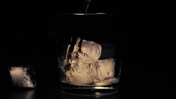 Slow mo whiskey in glass with ice — Stock Video