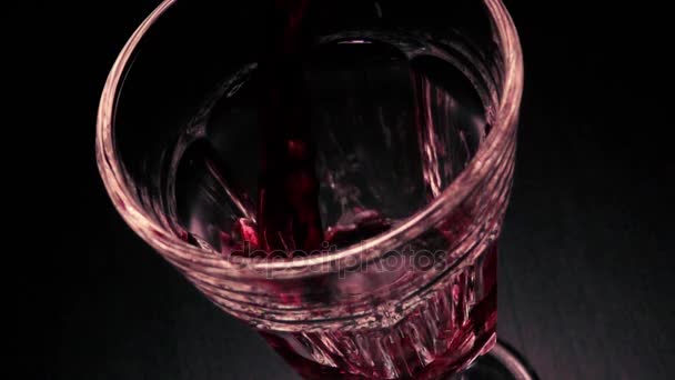 Медленно наливая красное вино в бокал граненый — стоковое видео