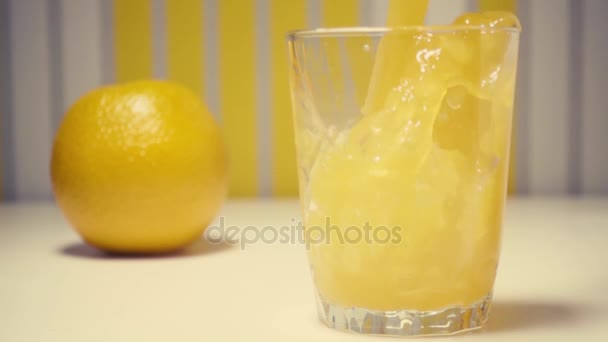 El jugo de naranja de cámara lenta con pulpa se vierte en un vaso — Vídeos de Stock