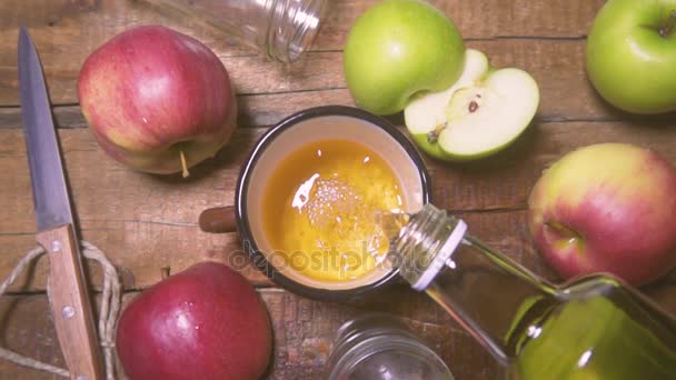 Из бутылки наливают свежий яблочный сок в стакан. Сельский стиль — стоковое видео