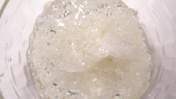 Супер медленный рис падает в воду вид сверху 960fps — стоковое видео