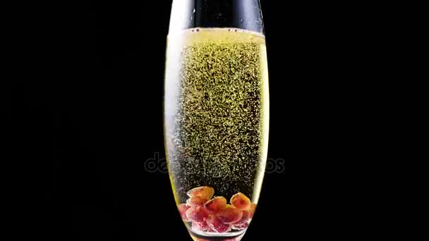 Pomegranate seeds in a glass of champagne — Stock Video