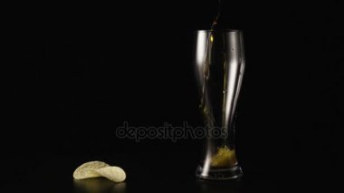 Bira güzel bir cam ve patates cipsi yakınındaki içine dökülür