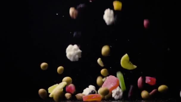 Сушеные фрукты и орехи падают на стол сверху медленно — стоковое видео