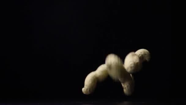 Cacahuetes sin cáscara en la cáscara cae sobre una mesa lenta mo — Vídeos de Stock