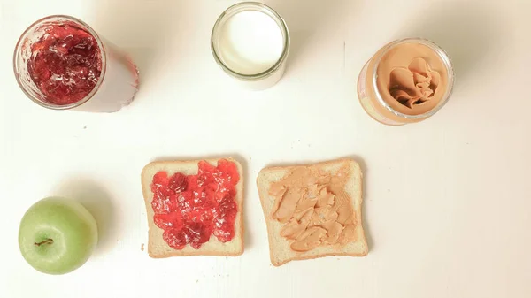 Reçel, fıstık ezmesi, bir bardak süt ve bir elma ile sandviç — Stok fotoğraf