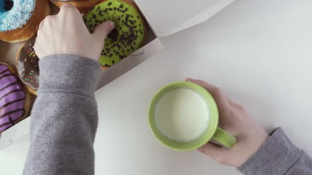 La mano de Childs saca un donut de la caja. Vista superior — Vídeos de Stock