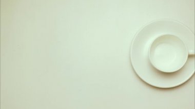 Stop motion, animasyon. Bir tabak ve bir fincan kahve bir fincan tabağı üzerinde çörek. Üstten Görünüm