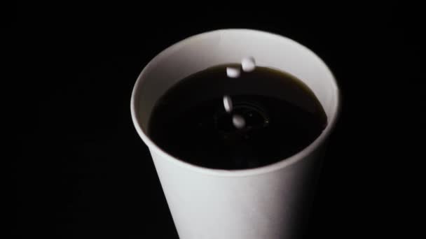 Αργή κίνηση. Μια χούφτα σταγόνες υποκατάστατα ζάχαρης σε ένα ποτήρι — Αρχείο Βίντεο