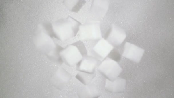 Кубики сахара падают на сахар. Медленно, вид сверху — стоковое видео