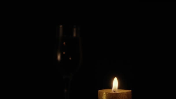 La bougie brûle sur un fond noir. Mouvement lent 
