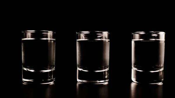 Trois verres de vodka sur fond noir — Photo