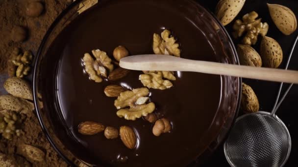Καρύδια αναμιγνύεται σε σοκολάτας με ένα κουτάλι. Αργή mo — Αρχείο Βίντεο