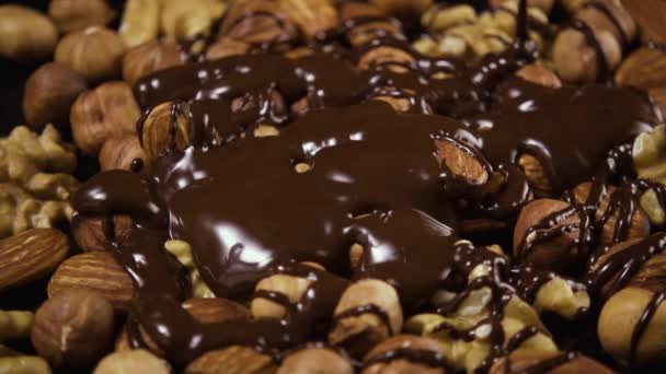 Una mezcla de frutos secos se vierte abundantemente con chocolate. Alta velocidad — Vídeo de stock