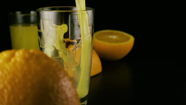 Más despacio. Jugo de naranja fresco verter en un vaso — Vídeos de Stock