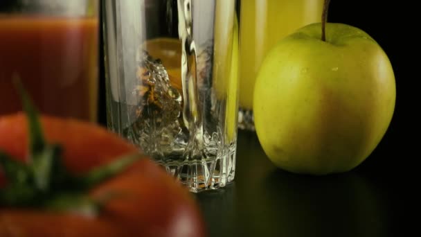 O suco de maçã é derramado em um dos três copos na mesa. Devagar. — Vídeo de Stock