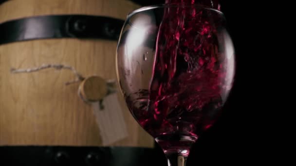 Wein wird in ein Glas auf dem Hintergrund eines Fasses gegossen. Zeitlupe — Stockvideo