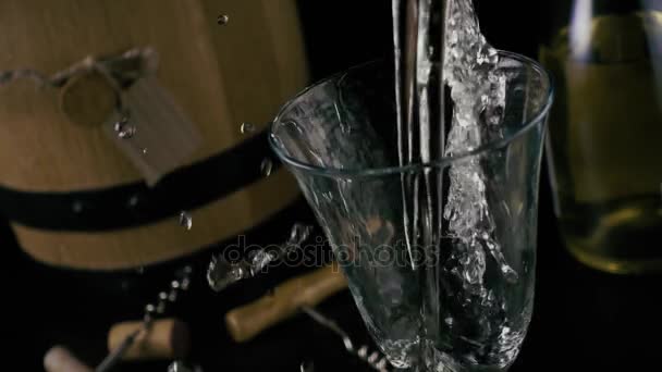 Slow-motion. Witte wijn wordt gegoten in een glas, drops drop uit een glas — Stockvideo