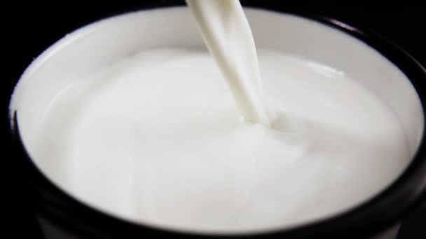 Süt akışı bir kupa dökülür. Ağır çekim — Stok video