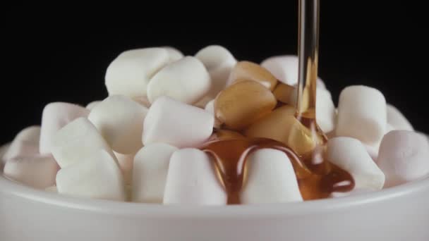 Αργή κίνηση. Marshmallow ρίχνετε ζεστό το σιρόπι πάνω σε μαύρο φόντο — Αρχείο Βίντεο