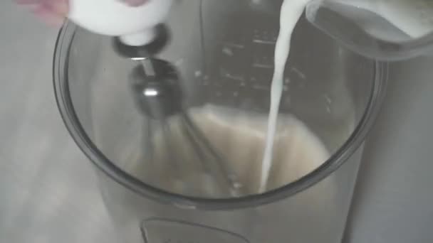 Slow mo. Teig mit einem Schneebesen verquirlen und die Milch hinzufügen — Stockvideo