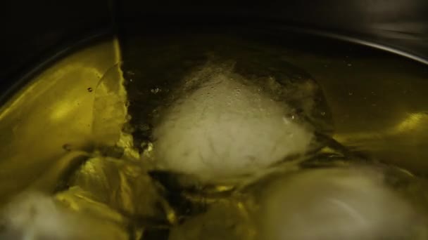 En cámara lenta. Cubos de hielo en una bebida alcohólica — Vídeos de Stock
