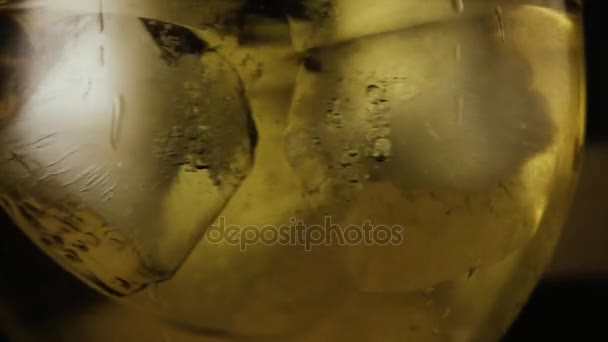 Αργή mo. πάγου στροβιλίζεται σε ένα ποτήρι με ένα ποτό — Αρχείο Βίντεο