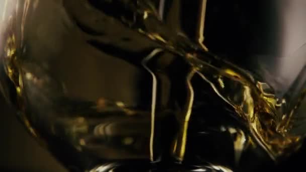 Au ralenti. Un jet de cognac se déverse dans le verre 