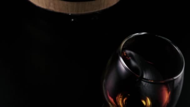 En cámara lenta. Una copa de brandy se despliega sobre la mesa — Vídeo de stock