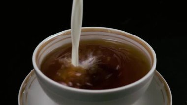 Bir fincan çay süt dökülen. Ağır çekim