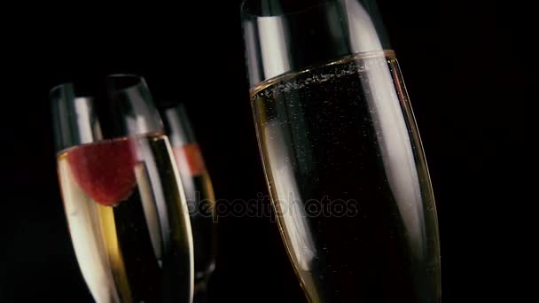 Drie glazen met champagne en aardbeien. Slow mo — Stockvideo