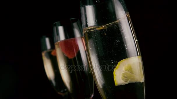 Slow mo. Een schijfje citroen druppels in champagne — Stockvideo