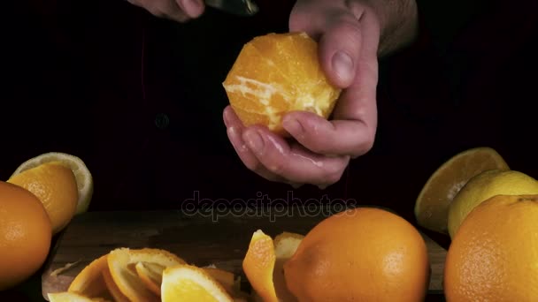 Мужчина режет кусочек апельсина — стоковое видео