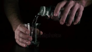 Bir adam bir cam içine su dökülen. Ağır çekim