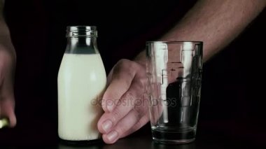 Mens el süt bir cam içine dökülen.
