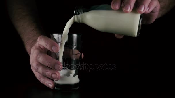 Más despacio. Manos para hombre verter la leche en un vaso — Vídeo de stock