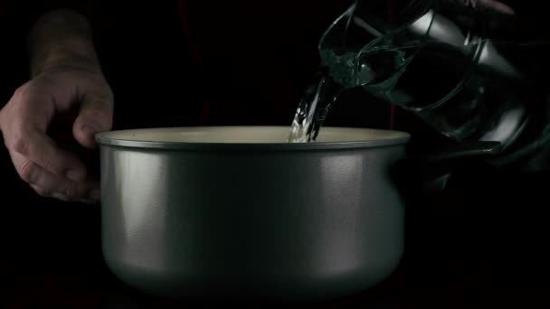The cook pours the water into the pan. Slow mo — Stock Video