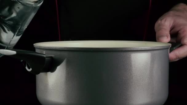 El cocinero vierte agua en la sartén — Vídeos de Stock
