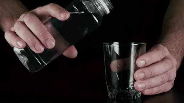 Male hands pour into a glass of water — Stock Video