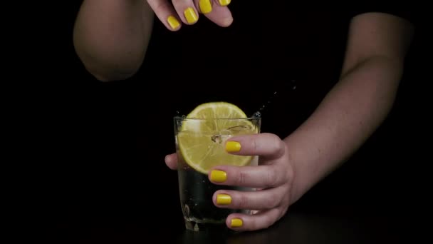 梨花の手がグラスにレモンをスローします。スローモーション — ストック動画