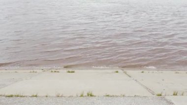 Beton döşeme ile bir su birikintisi kıyısında