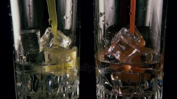 Zwei Gläser Eis und Wodka gießen Saft. Zeitlupe — Stockvideo