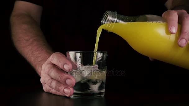 Slow motion. The juice is poured into a glass with ice and vodka — Stock Video