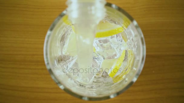 L'eau de citron se déverse dans un verre avec vue sur la glace. Moteur lent — Video