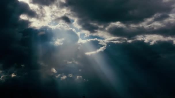 Солнечные лучи светят сквозь облака — стоковое видео