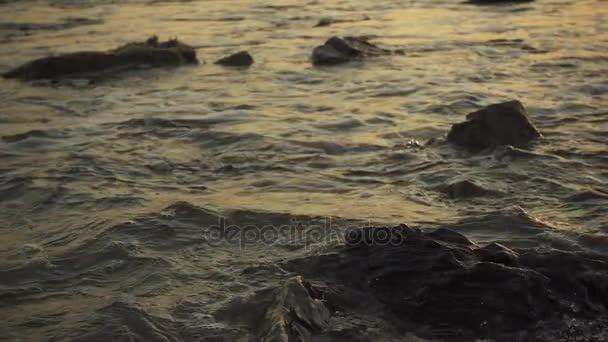 Salpicadura de pequeñas olas en las rocas al atardecer cámara lenta — Vídeos de Stock