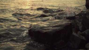 Bir dalga su sıçramalarına taşlı shore yavaş mo üzerinde