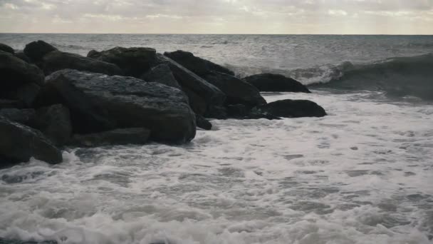 On a group of large stones rolling wave slow motion — Stock Video