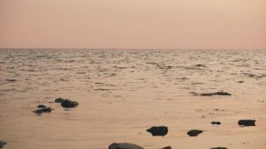 Gün batımında hafif bir dalgalanma ile sakin deniz