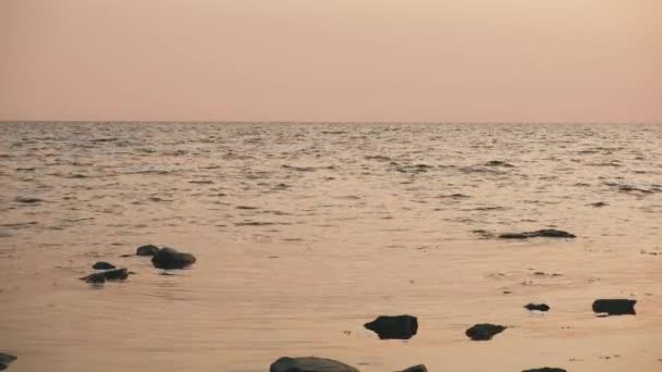 Mer calme avec une légère ondulation au coucher du soleil — Video